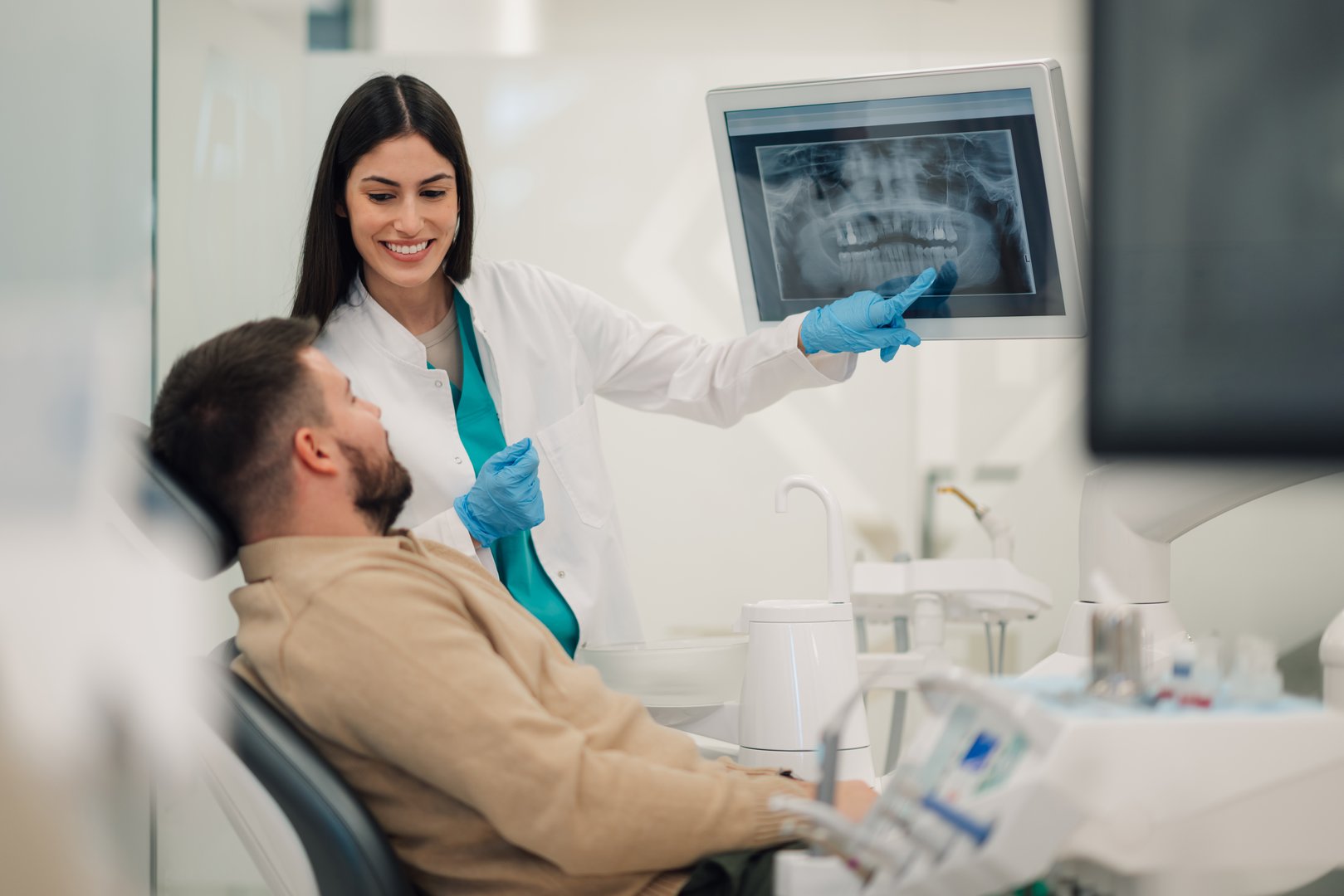 Dentist showing a teeth x-ray to a patient in a modern dental clinic